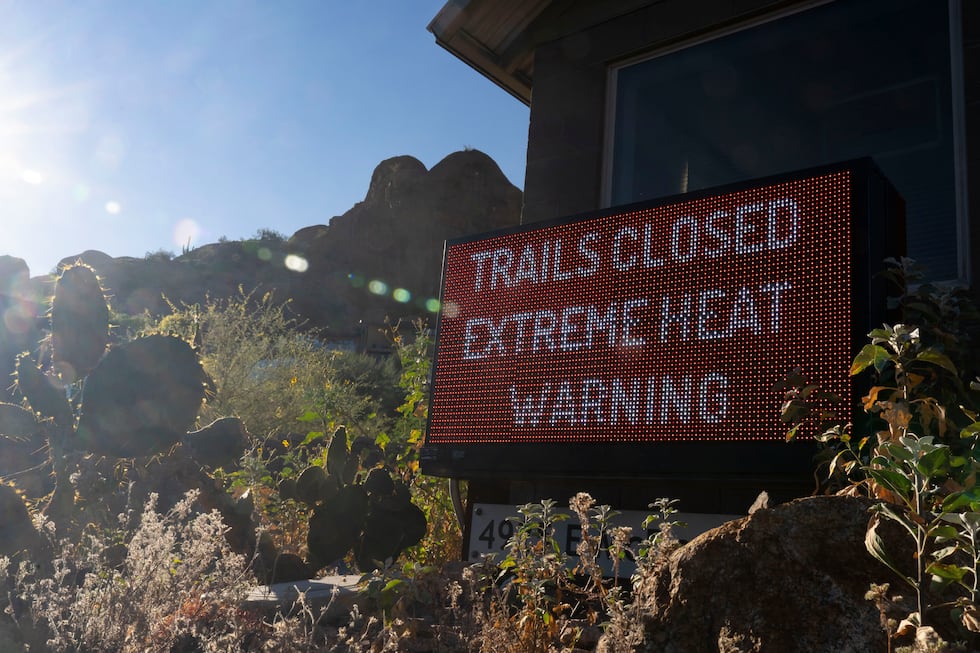 A sign warns hikers of trail closures due to extreme heat at Camelback Mountain on Thursday,...