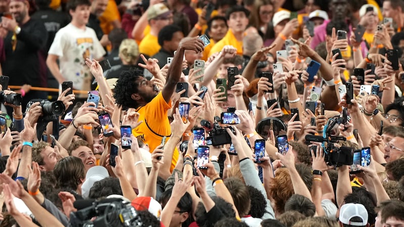 Arizona State guard Maurice Odum celebrates with fans after defeating Kansas during an NCAA...